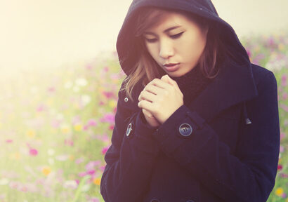 young woman wearing black cloth very cold in flower garden