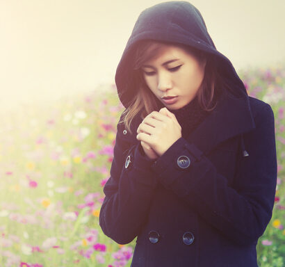 young woman wearing black cloth very cold in flower garden
