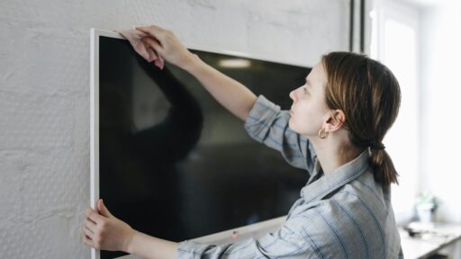 a woman wiping a television with a cloth