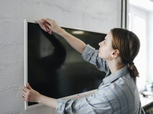 a woman wiping a television with a cloth