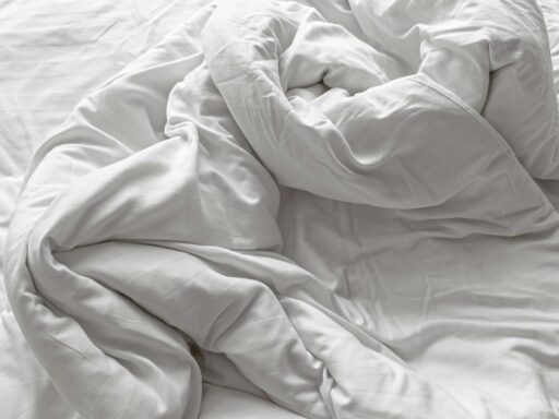 close up view of disheveled and wrinkled white soft linen blanket